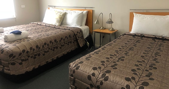 queen and single beds in the room of Ohariu one-bedroom unit